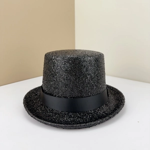 Détail d'un chapeau haut-de-forme noir scintillant avec un ruban gros-grain élégant