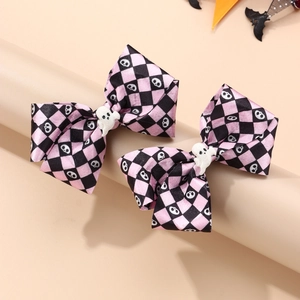 Detail of pink and black plaid Halloween bow hair clips with cute white ghost center decoration