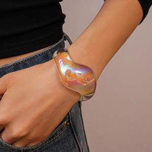 Detail of chunky iridescent acrylic bangle featuring vibrant rainbow metallic gloss