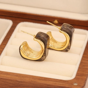 Détail des boucles d'oreilles vintage en C avec résine ambre et acier inoxydable doré