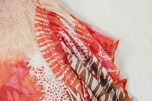 Detail of vibrant abstract print on mesh fabric with elegant ruffle and pleated texture