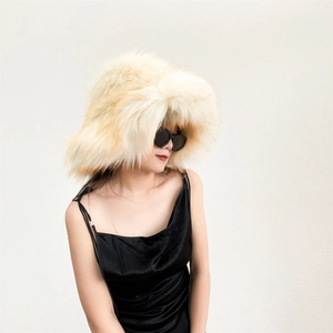 Close-up of fluffy faux fur winter bucket hat in cream color with long plush texture