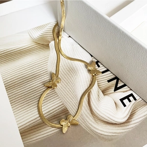 Macro shot of gold butterfly pendants with brushed texture on a sleek snake chain