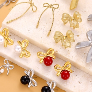Boucles d'oreilles nœuds dorées 18K avec perles sur fond de pierre minimaliste chic