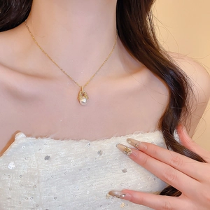 Nahaufnahme der 18k vergoldeten Perlenkette mit Zirkon auf dem Hals und Schlüsselbein