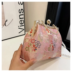 Detail of pink embroidered cherry blossom handbag with pearl clasp and metal frame