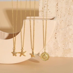 Detail of four gold starfish and shell pendants with zircon stones on thin gold chains