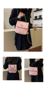 Pink quilted crossbody bag with silver chain strap and heart logo shown on model