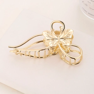 Detail of elegant gold butterfly hair claw clip with metallic finish and alloy texture