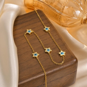 Detailed macro of gold star pendants with blue evil eye motif on delicate chain link