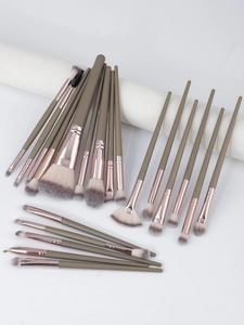 Detail of 22-piece professional makeup brush set with green handles and rose gold ferrules