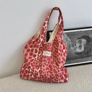 Close-up of leopard print canvas tote bag with woven studio label and interior lining