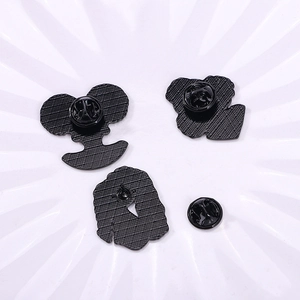 Rear view of four black metal pins with butterfly clasps and textured grid finish