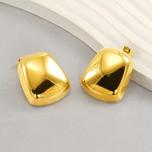 Détail macro de boucles d'oreilles rectangulaires en acier inoxydable doré à la finition brillante