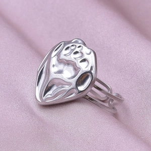 Detail of silver hollowed heart ring with double-layered band on pink silk background