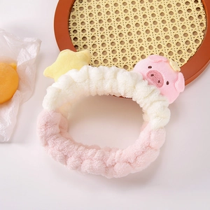 Détail du bandeau en peluche rose et blanc avec décorations de cochon et d'étoile