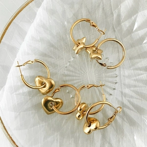 Gold-plated stainless steel hoop earrings set with heart and star charms on white tulle