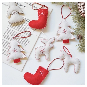 Close-up of handmade red and white wool felt Christmas tree and elk ornaments