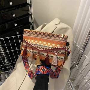 Detail of bohemian woven crossbody bag featuring colorful tassels and geometric patterns