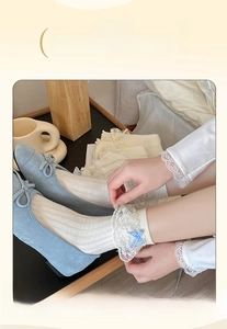 Detail of white lace socks with blue gingham bow paired with light blue suede flats
