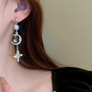 Detail of silver star and moon tassel earrings with sparkling rhinestones on model