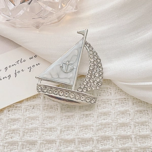 Dettaglio macro della spilla a forma di barca a vela in argento con strass ed smalto
