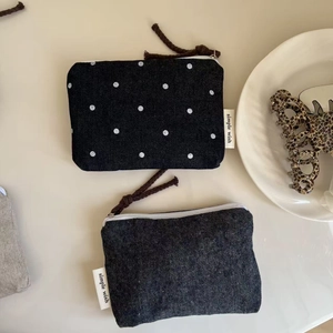 Detailed shot of mini denim and polka dot canvas pouches with rope zipper pulls