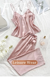 Vue détaillée d'un ensemble de pyjama rose en satin avec caraco et pantalon sur tissu blanc