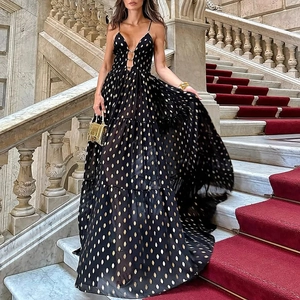 Detail shot of black deep V-neck dress with golden polka dots and tiered skirt layers
