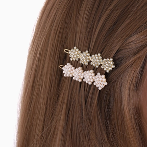 Detailed view of hair clips with sparkling rhinestones and white pearls on brown hair