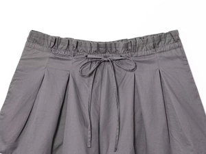 Detail of grey poplin shorts featuring an elastic drawstring waist and refined pleats