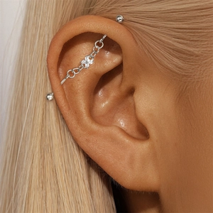 S925 silver industrial barbell piercing with diamond clover detail and chain on ear