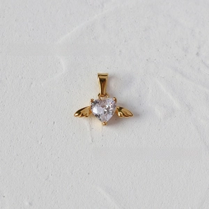 Detail of winged heart pendant featuring a centered white zircon in 18K gold-plated finish