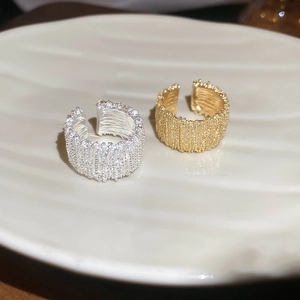 Detailed view of gold and silver rings with lava texture on a white ceramic shell plate