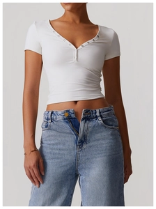 Close-up of white brushed breathable yoga tee with V-neckline and metallic buttons