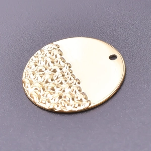 Close-up of golden 18k plated stainless steel round pendant with hammer texture detail