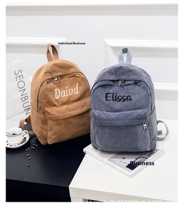 Detail of corduroy backpacks with custom name embroidery in brown and blue colors