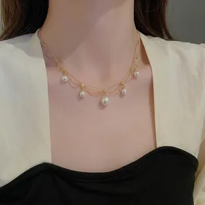 Elegant gold-plated pearl fringe necklace featuring multilayered strands on an Asian model