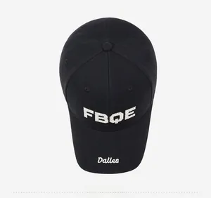 Top view detail of black baseball cap showing white FBQE embroidery and curved brim
