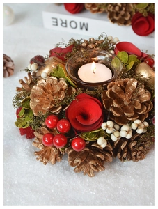 Christmas wreath candle holder with glass cup, golden pine cones and lit white candle