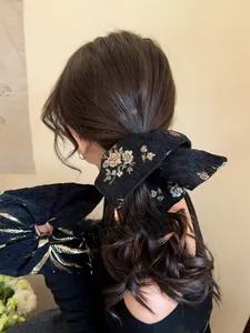 Detail of elegant black jacquard hair scrunchie with floral embroidery on hair