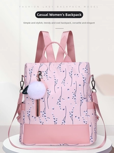 Detailed front view of pink floral backpack with fuzzy pompom and secure zipper pocket
