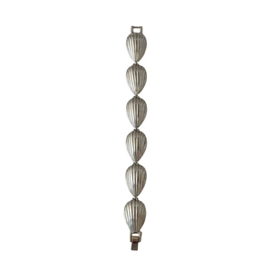 Detailed view of silver shell-shaped link bracelet with radial textures and metal clasp