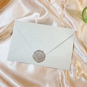 Close-up of vintage cream envelope with a For You wax seal on champagne silk fabric