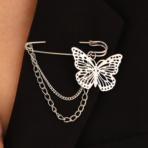 Silver butterfly chain brooch pinned on a black suit lapel with hollow wing details
