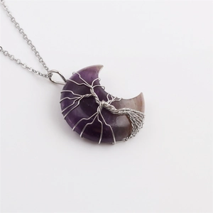 Detail of crescent moon pendant with purple stone and silver tree of life wire wrapping