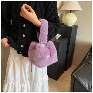 Detail of a purple fluffy bucket bag featuring soft plush texture and a small handle