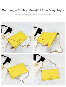 Detail view of yellow envelope clutch bag with metal trim and golden chain strap