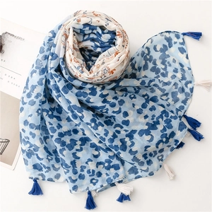 Detailed macro view of the blue and white leopard print scarf with fringe tassels