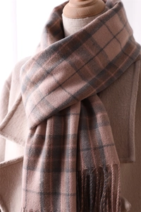 Close-up of the soft texture and tassel details on a brown plaid cashmere-like scarf
